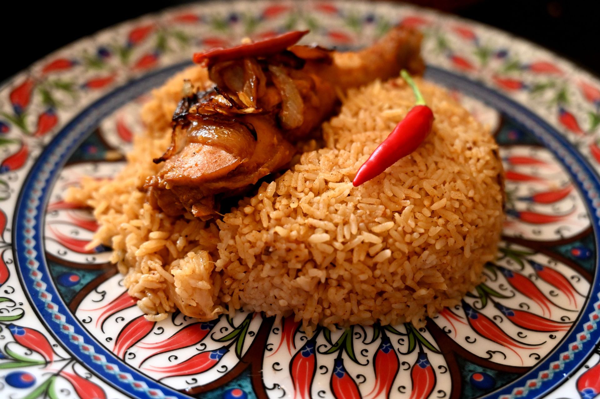 Close-up of chicken biryani with chili on a decorative plate from Chattogram.